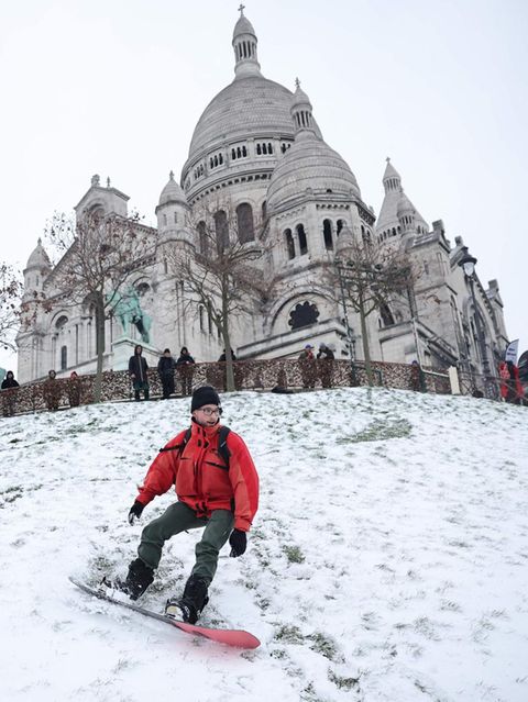 Ein schwerer Schneesturm hat die französische Hauptstadt getroffen und für erhebliche Beeinträchtigungen im Straßenverkehr gesorgt – aber auch für Freude. In der Nähe der Basilika Sacré-Cœur im Stadtteil Montmartre rutschen Menschen auf dem Schnee den Hügel hinunter. Dieser Mann nutzt ein Snowboard
