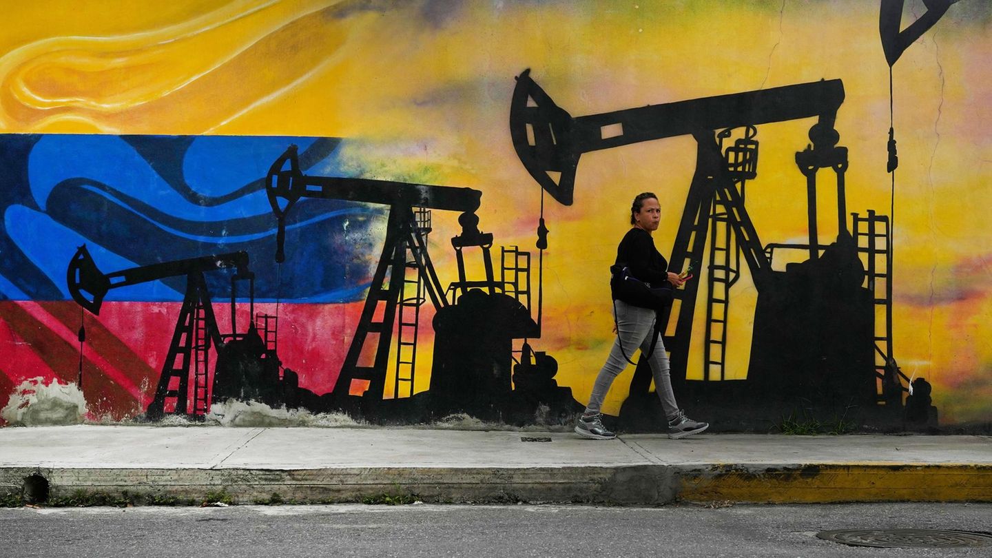 Eine Passantin geht in Caracas, der Hauptstadt Venezuelas, an einem Wandgemälde mit Ölpumpen vorbei