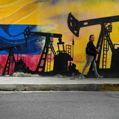 Eine Passantin geht in Caracas, der Hauptstadt Venezuelas, an einem Wandgemälde mit Ölpumpen vorbei