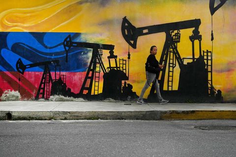 Eine Passantin geht in Caracas, der Hauptstadt Venezuelas, an einem Wandgemälde mit Ölpumpen vorbei