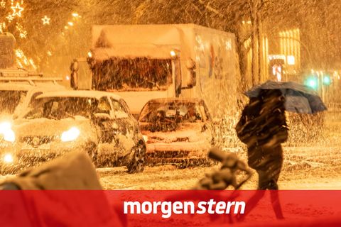 Eine Frau überquert bei starkem Schneetreiben in Hamburg die Straße. Deutschland droht ein Wintersturm
