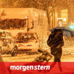 Eine Frau überquert bei starkem Schneetreiben in Hamburg die Straße. Deutschland droht ein Wintersturm