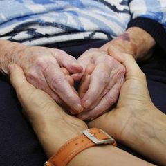 Symbolbild Erbe: Zwei Hände einer jüngeren Person umschließen die einer älteren