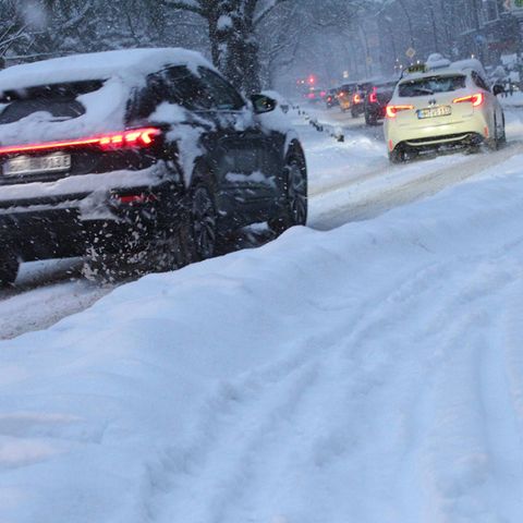 Autos fahren durch verschneite Stadt: Schnee-Chaos in Hamburg