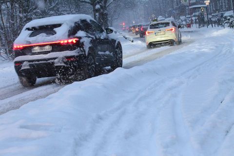 Autos fahren durch verschneite Stadt: Schnee-Chaos in Hamburg
