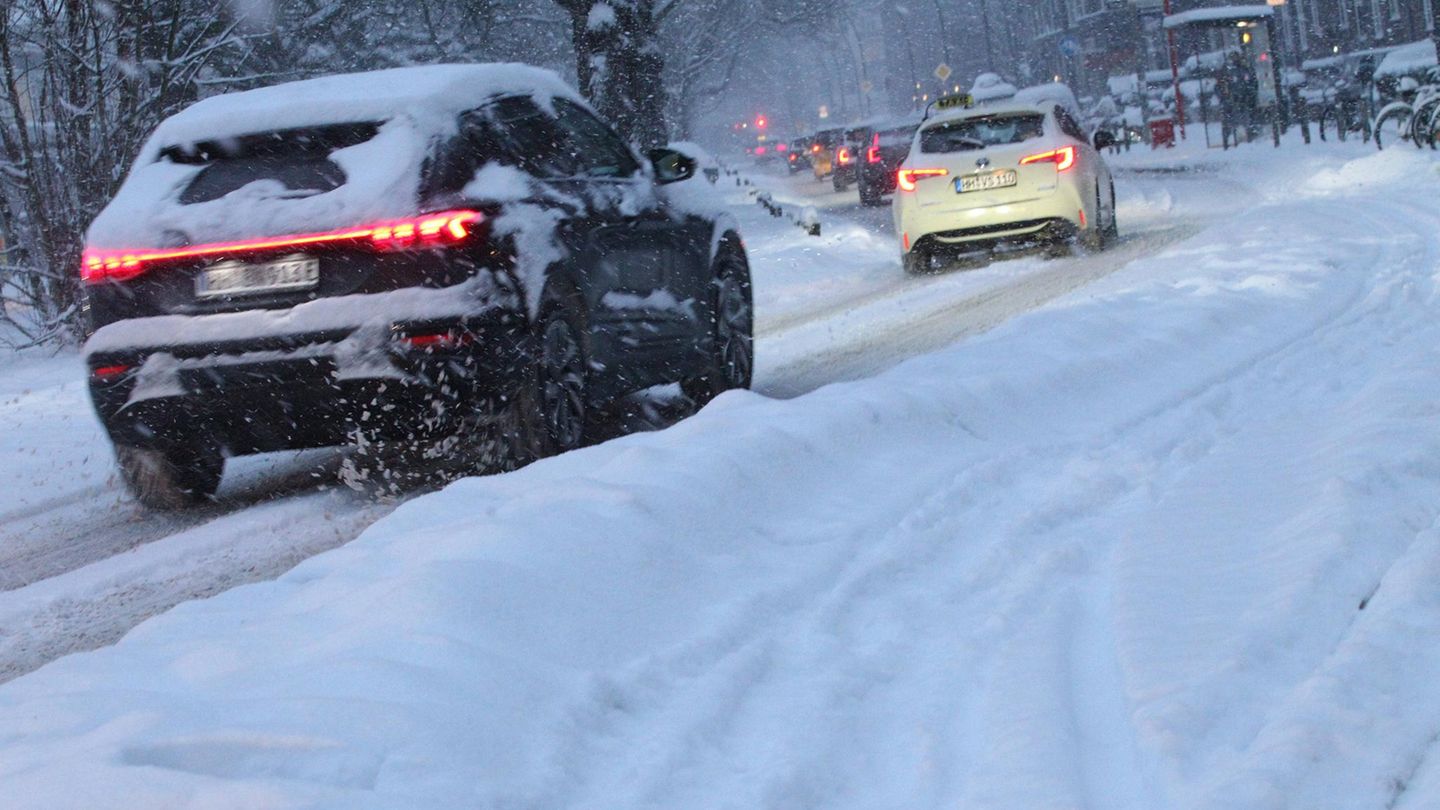 Autos fahren durch verschneite Stadt: Schnee-Chaos in Hamburg