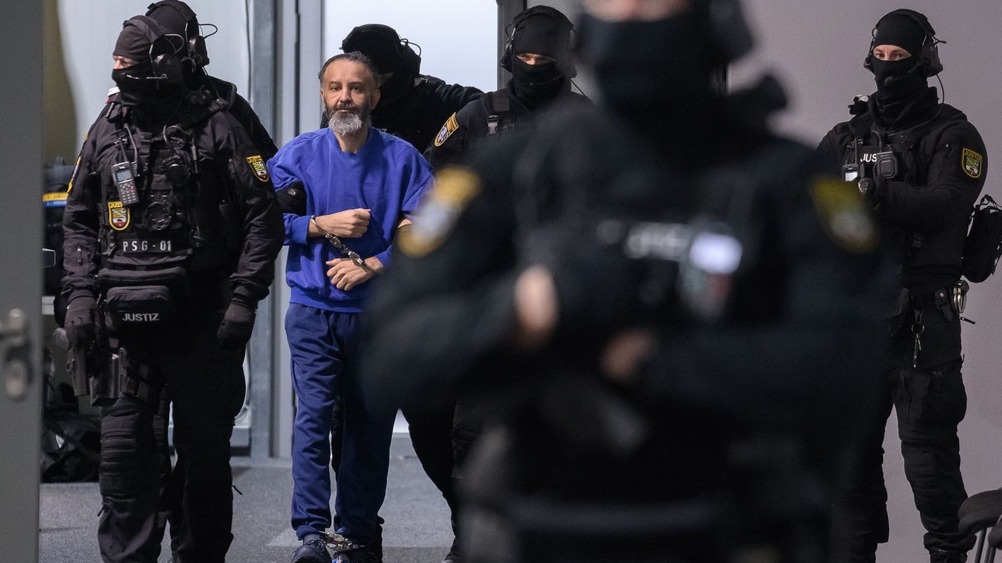 Justizbeamte führen den Angeklagten Taleb al-Abdulmohsen in den Gerichtssaal des temporären Gerichtsgebäudes vom Landgericht Mag