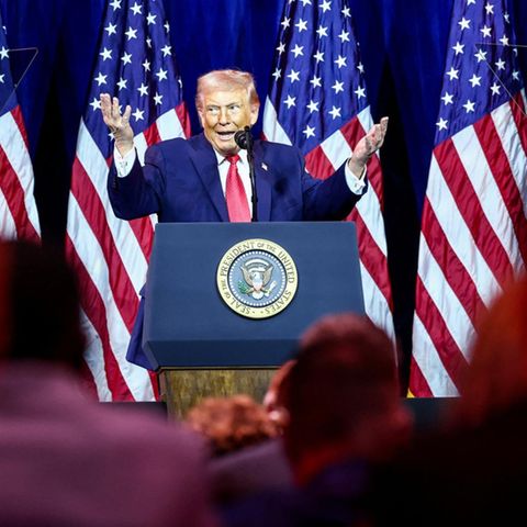 US-Präsident Donald Trump auf einer Bühne, hinter ihm USA-Flaggen