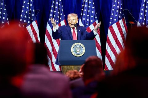 US-Präsident Donald Trump auf einer Bühne, hinter ihm USA-Flaggen