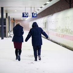 Zwei Bahn-Mitarbeiterinnen laufen am frühen Morgen über den Hauptbahnhof Hannover. Foto: Moritz Frankenberg/dpa