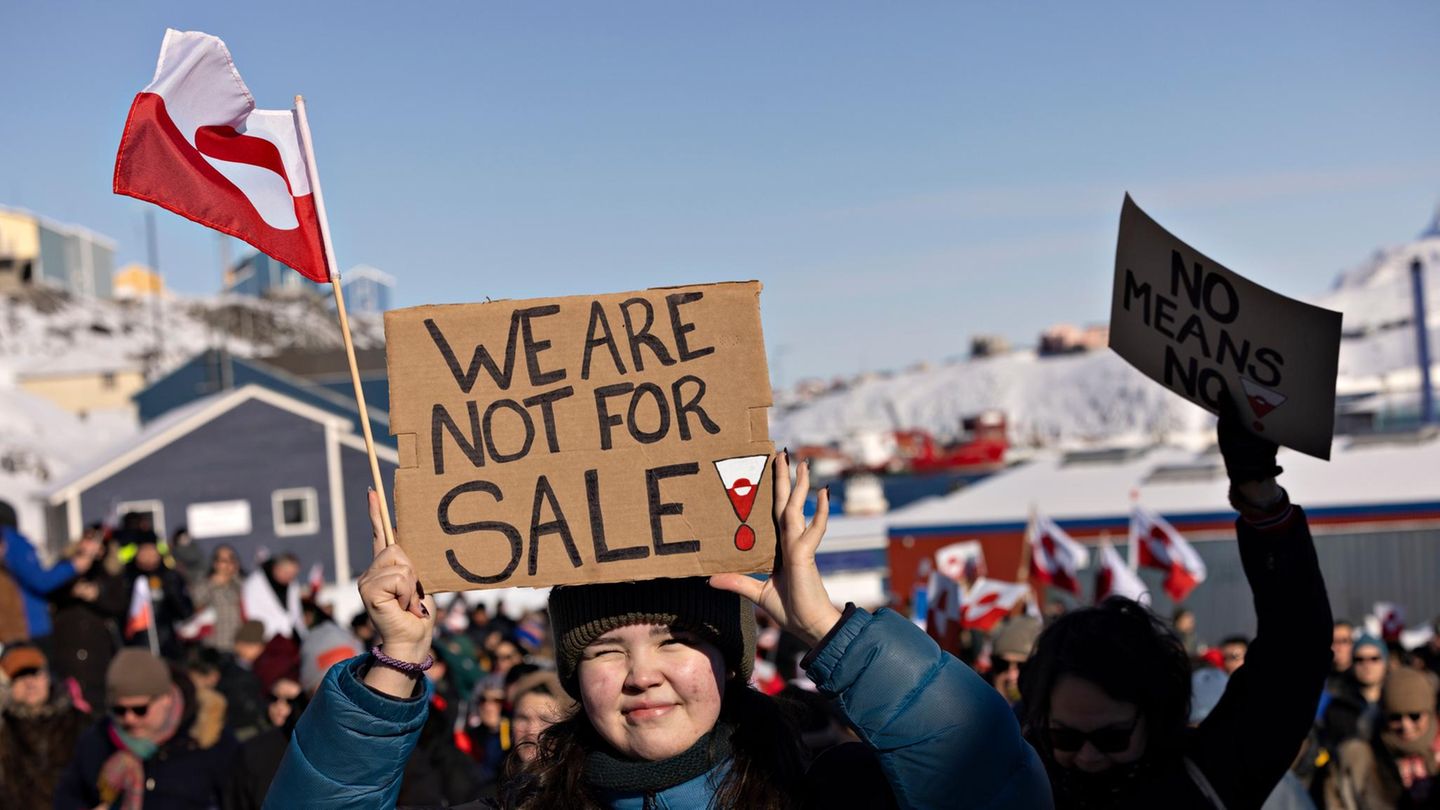 Eine Frau in Grönland hält ein Schild hoch, auf dem auf englisch steht: "Wir stehen nicht zum Verkauf."