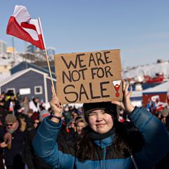 Eine Frau in Grönland hält ein Schild hoch, auf dem auf englisch steht: "Wir stehen nicht zum Verkauf."