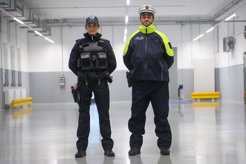 Eine Polizistin und ein Polizist tragen im Lager der Polizeiinspektion Zentrale Dienste der Bereitschaftspolizei die neue Streif