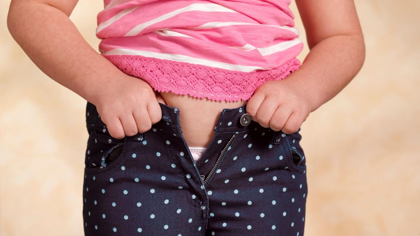 Ein Mädchen kann seine Hose nicht mehr zuknöpfen