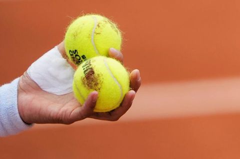 Hand die zwei Tennisbälle hält (Symbolbild)