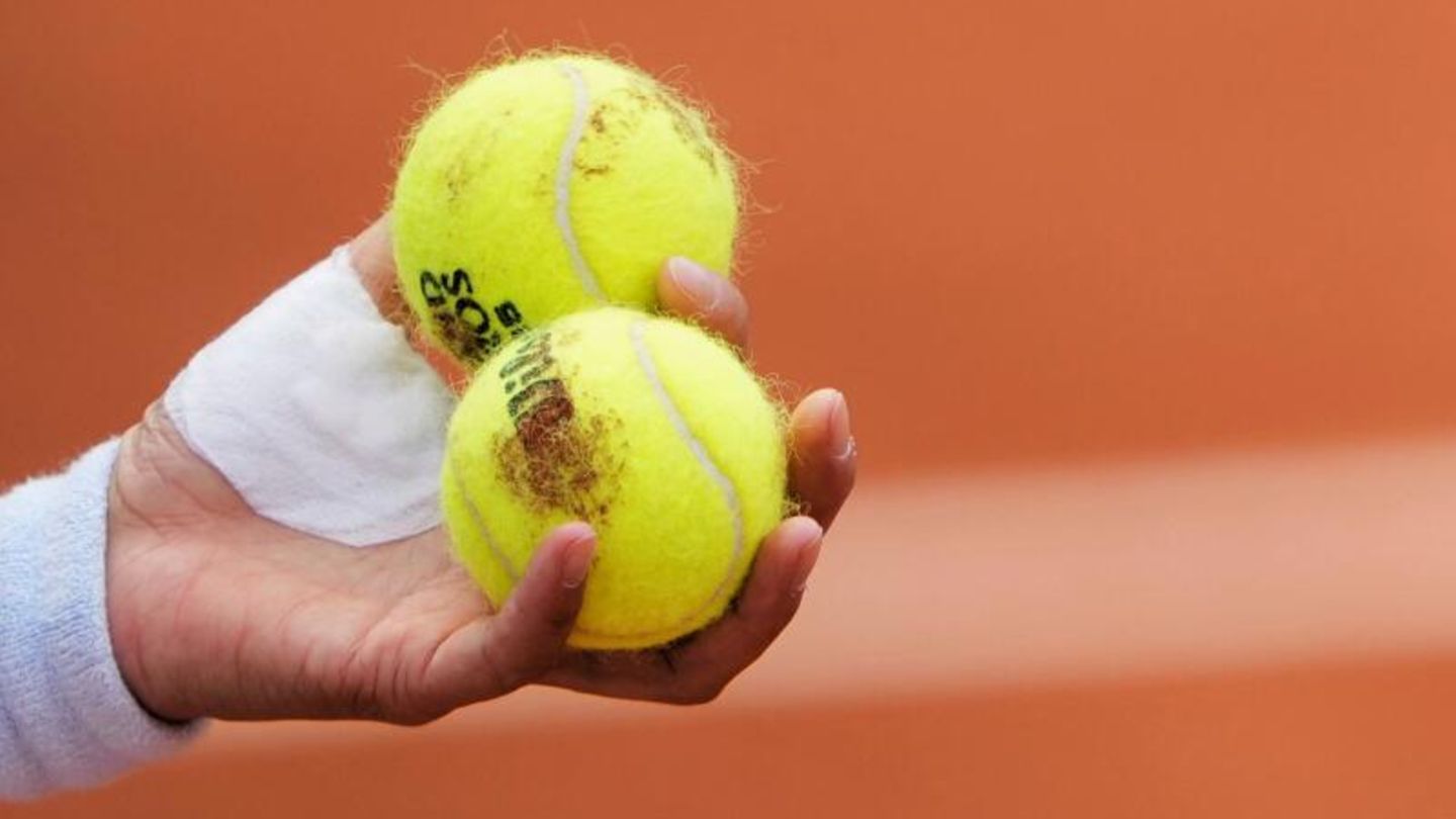 Hand die zwei Tennisbälle hält (Symbolbild)