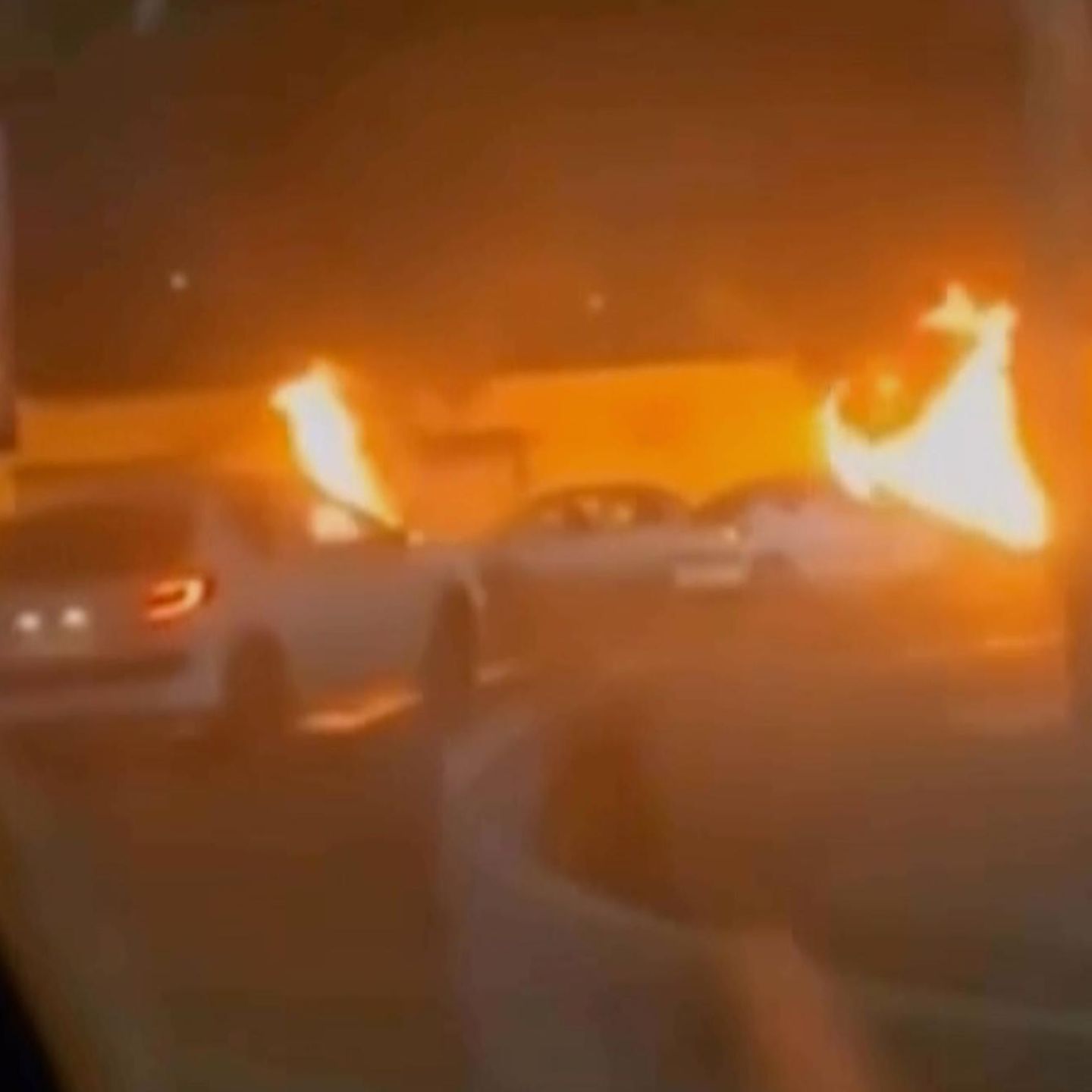 Dieses Videostandbild aus dem iranischen Staatsfernsehen zeigt brennende Fahrzeuge während nächtlicher Massenproteste