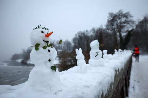 Zahlreiche kleine und winzige Schneefiguren stehen auf einer Mauer der Krugkoppelbrücke an der Alster. Foto: Christian Charisius
