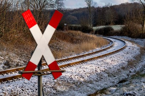 Mitten auf einem Bahnübergang kam ein Auto im dichten Schnee zum Stehen. (Symbolbild) Foto: Axel Heimken/dpa
