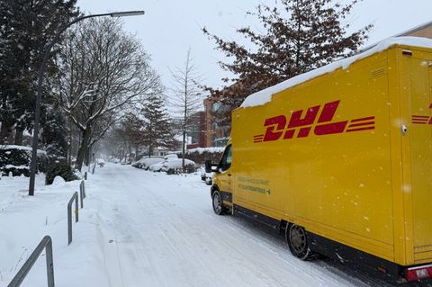Ein DHL-Lieferfahrzeug ist auf einer verschneiten Straße im Hamburger Stadtteil Lokstedt unterwegs. Foto: Stephanie Lettgen/dpa