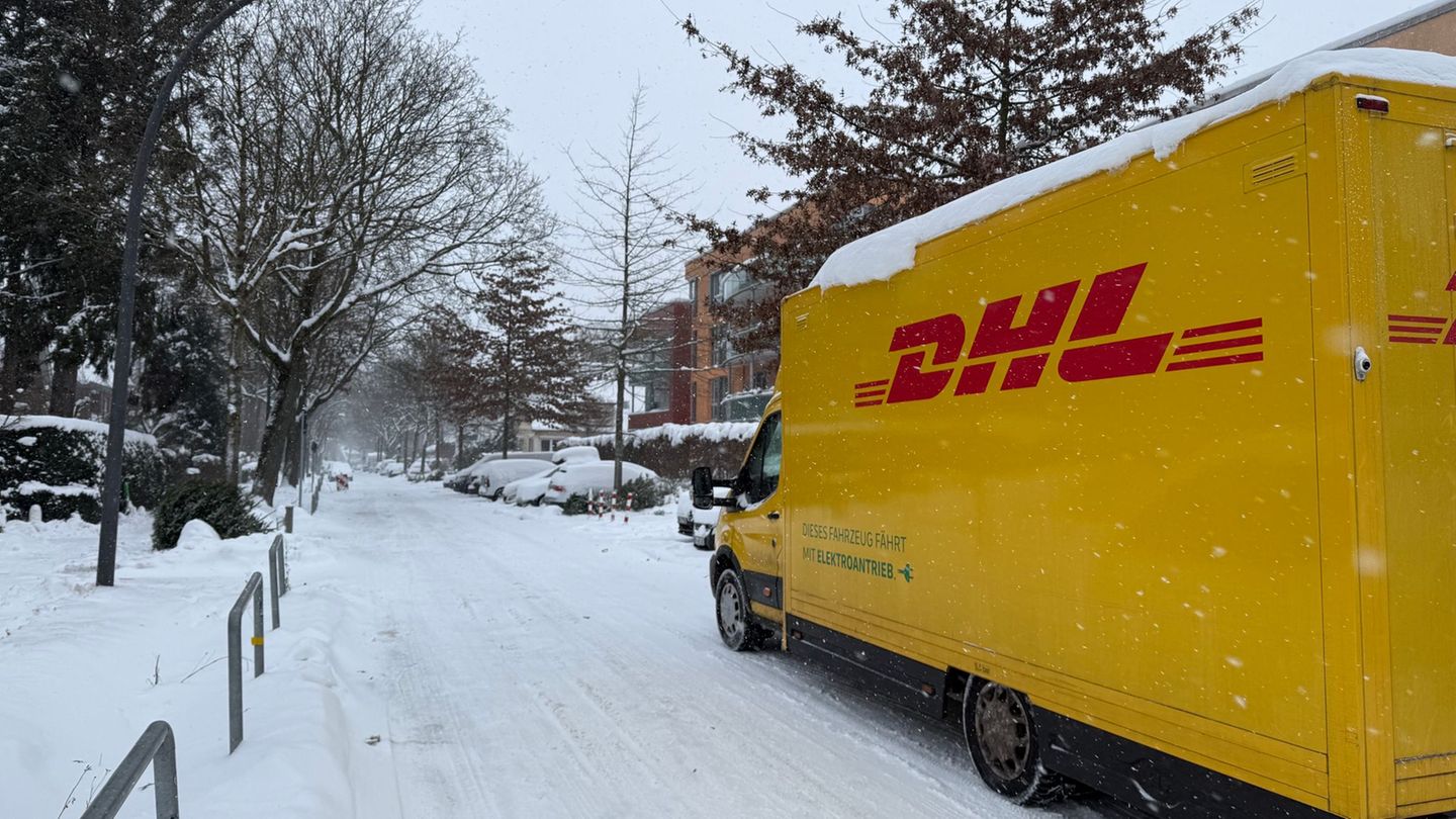 Ein DHL-Lieferfahrzeug ist auf einer verschneiten Straße im Hamburger Stadtteil Lokstedt unterwegs. Foto: Stephanie Lettgen/dpa