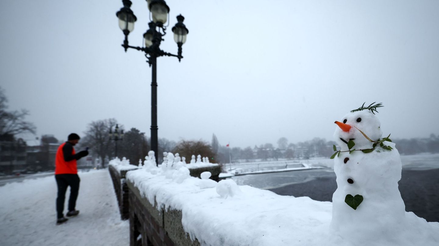 Schneemänner zieren die Krugkoppelbrücke an der Alster. Foto: Christian Charisius/dpa