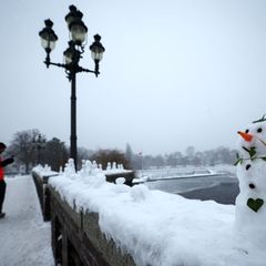 Schneemänner zieren die Krugkoppelbrücke an der Alster. Foto: Christian Charisius/dpa