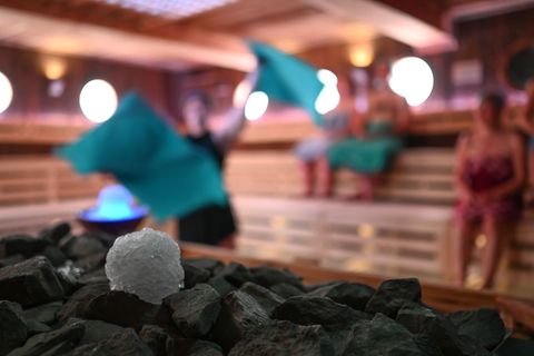Schneebälle aus Crushed Ice liegen in der Koggen-Sauna in Ostfriesland neben einem Sauna-Ofen - vielleicht etwas für einen kalte
