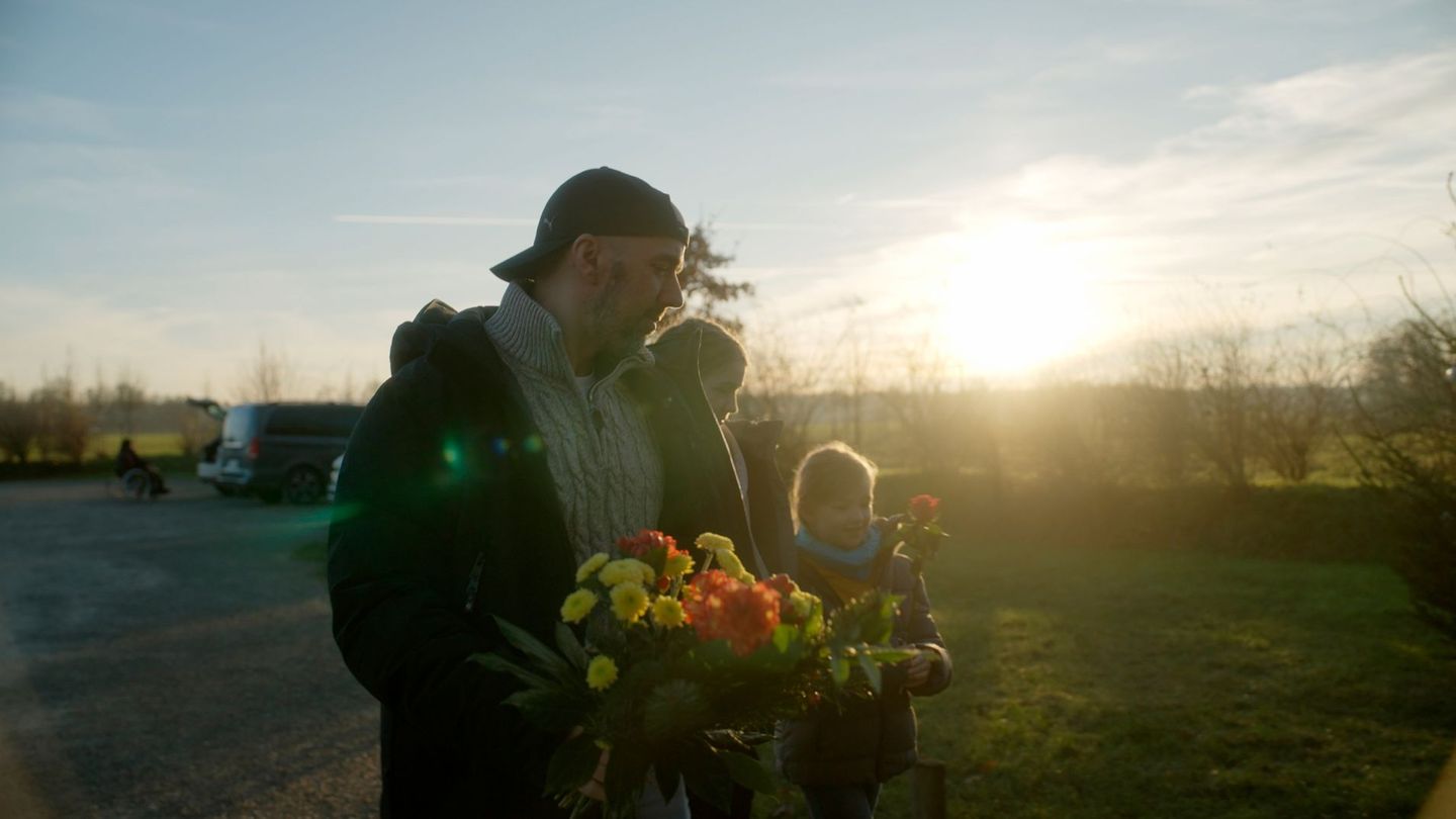 Am Geburtstag seiner verstorbenen Frau Moni besuchen Jörn und seine beiden Kinder das Grab von Moni im Friedwald.