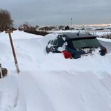 Ein Auto steht völlig eingeschneit im Schnee