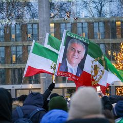 "Reza Pahalvi, König des Iran" steht auf einem Schild, das Iraner bei einer Demonstration in Berlin hochhalten