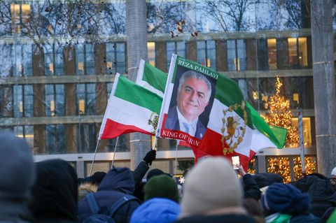 "Reza Pahalvi, König des Iran" steht auf einem Schild, das Iraner bei einer Demonstration in Berlin hochhalten