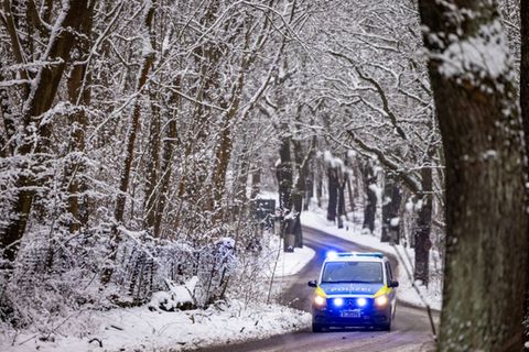 Polizeiauto in verschneitem Waldstück