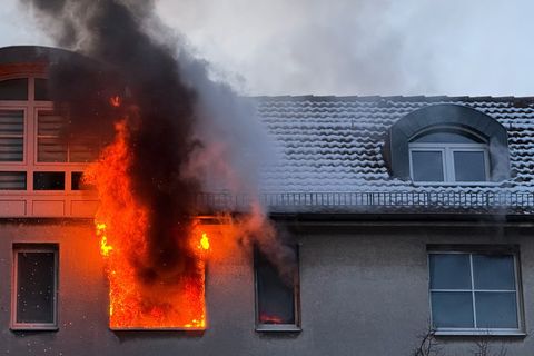 Feuer schlägt während eines Brandes aus dem Fenster eines Hauses. Foto: Sebastian Gollnow/dpa
