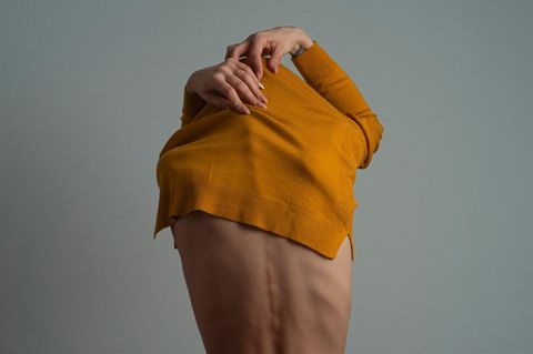 Eine Frau zieht einen Wollpullover aus