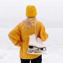 Schlittschuhlaufen: Frau mit Schlittschuhen von hinten