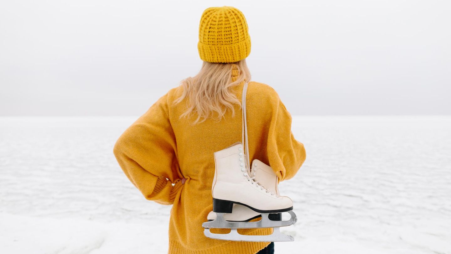 Schlittschuhlaufen: Frau mit Schlittschuhen von hinten