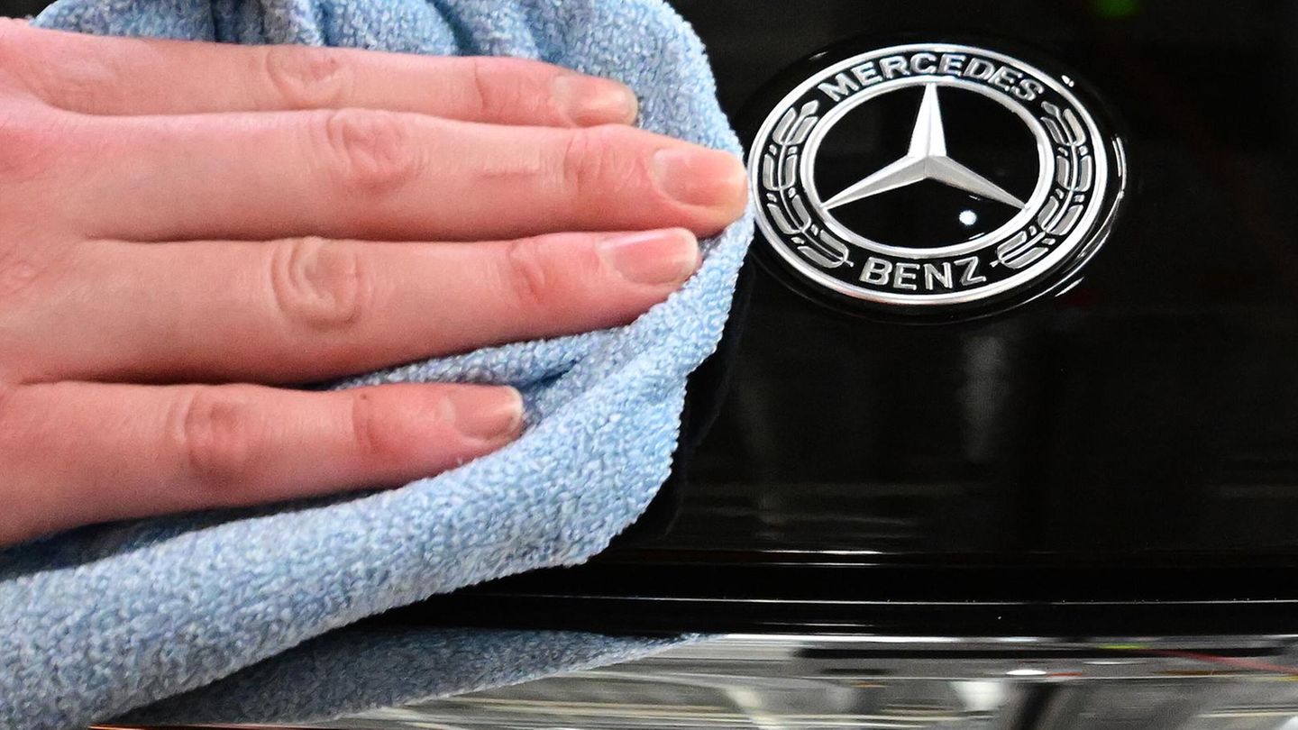 Eine Mitarbeiterin poliert die Motorhaube eines Mercedes