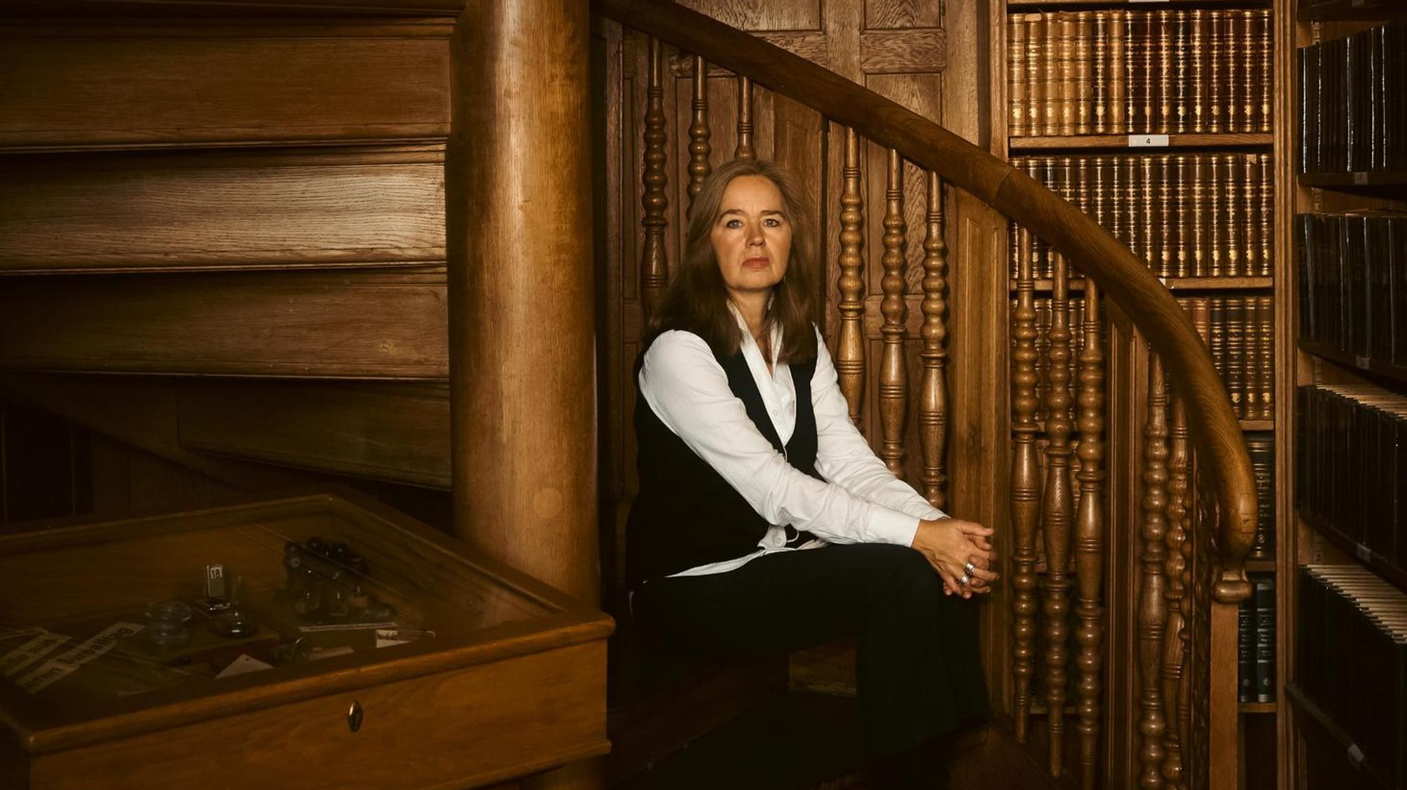 Anne Meier-Göring sitzt auf einer hölzenen Wendeltreppe