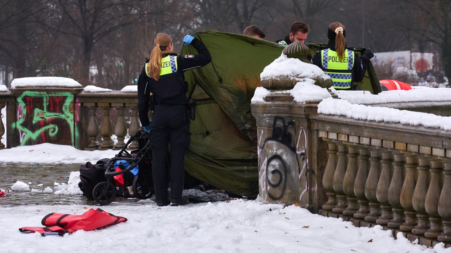 Polizeibeamtinnen und -beamte ermitteln rund um das Zelt auf der Lombardsbrücke, in dem ein toter Mann gefunden wurde. Foto: Mar
