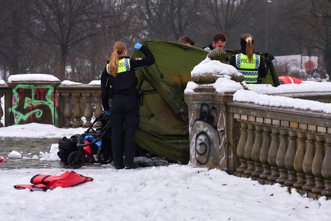 Polizeibeamtinnen und -beamte ermitteln rund um das Zelt auf der Lombardsbrücke, in dem ein toter Mann gefunden wurde. Foto: Mar
