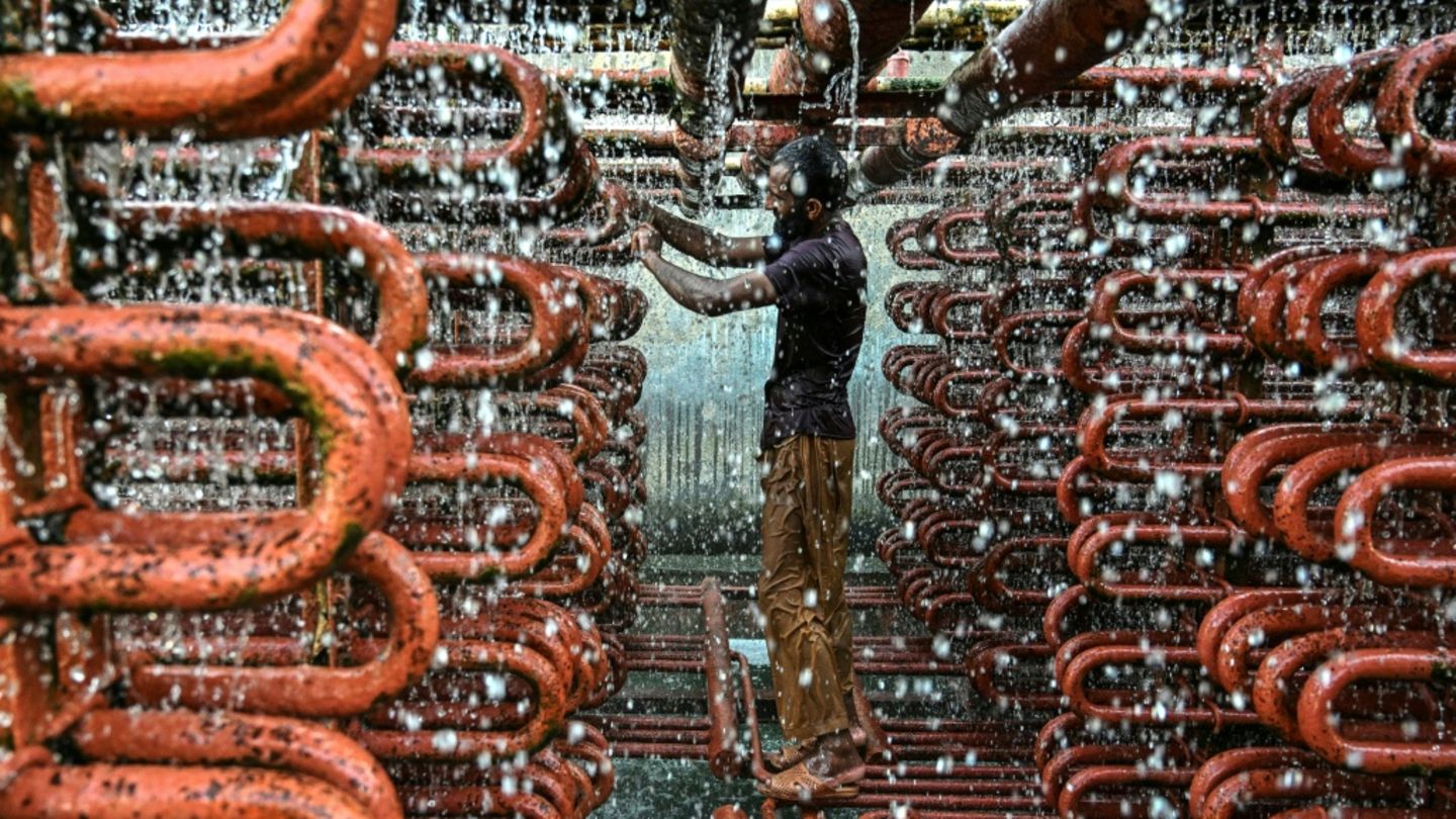 Ein Arbeiter reinigt Kühlturm-Leitungen in Karachi