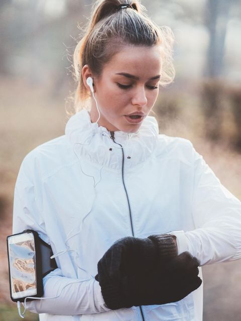 Fitness: Frau beim Joggen blickt auf ihren Fitnesstracker