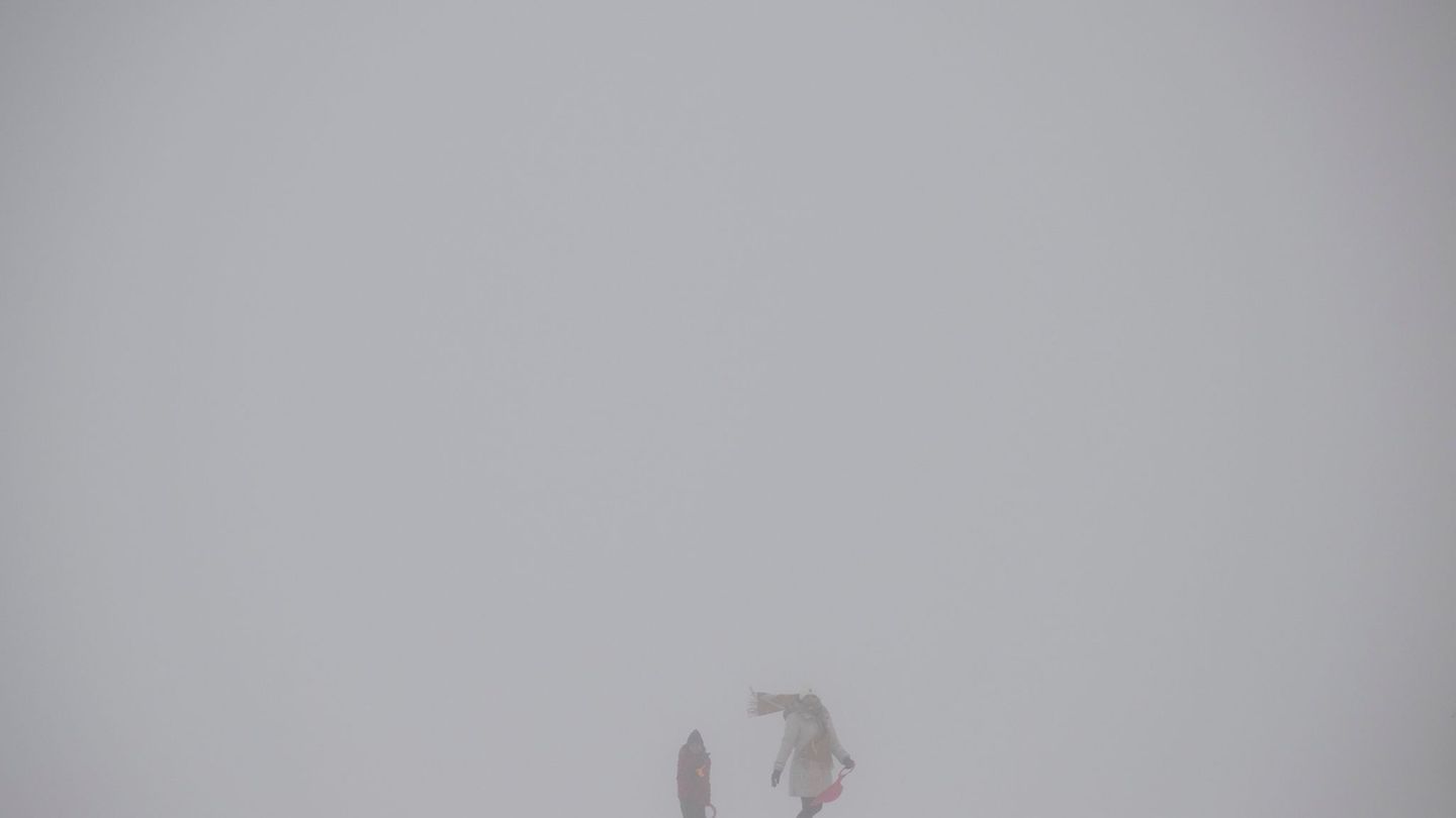 Spaziergänger in dichtem Nebel auf dem Feldbergplateau. Können wir noch Winter? Foto: Boris Roessler/dpa