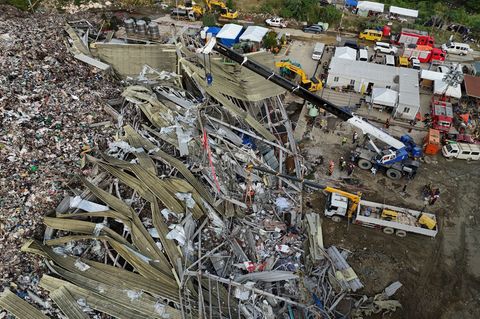 Die Einsatzkräfte suchen unter anderem mit einem Kran in den Abfall-Massen. Foto: Jacqueline Hernandez/AP/dpa
