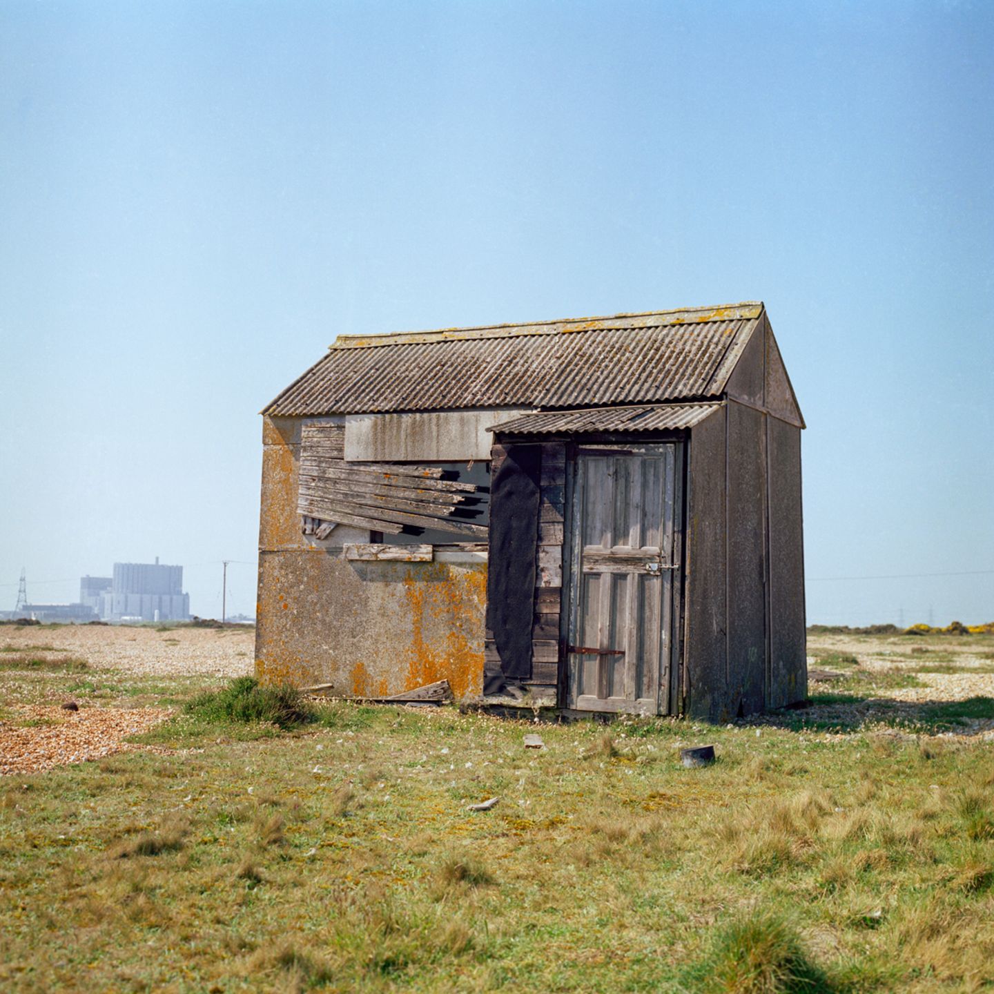Eine kleine Holzhuette, welche alleine auf einer Wiese steht