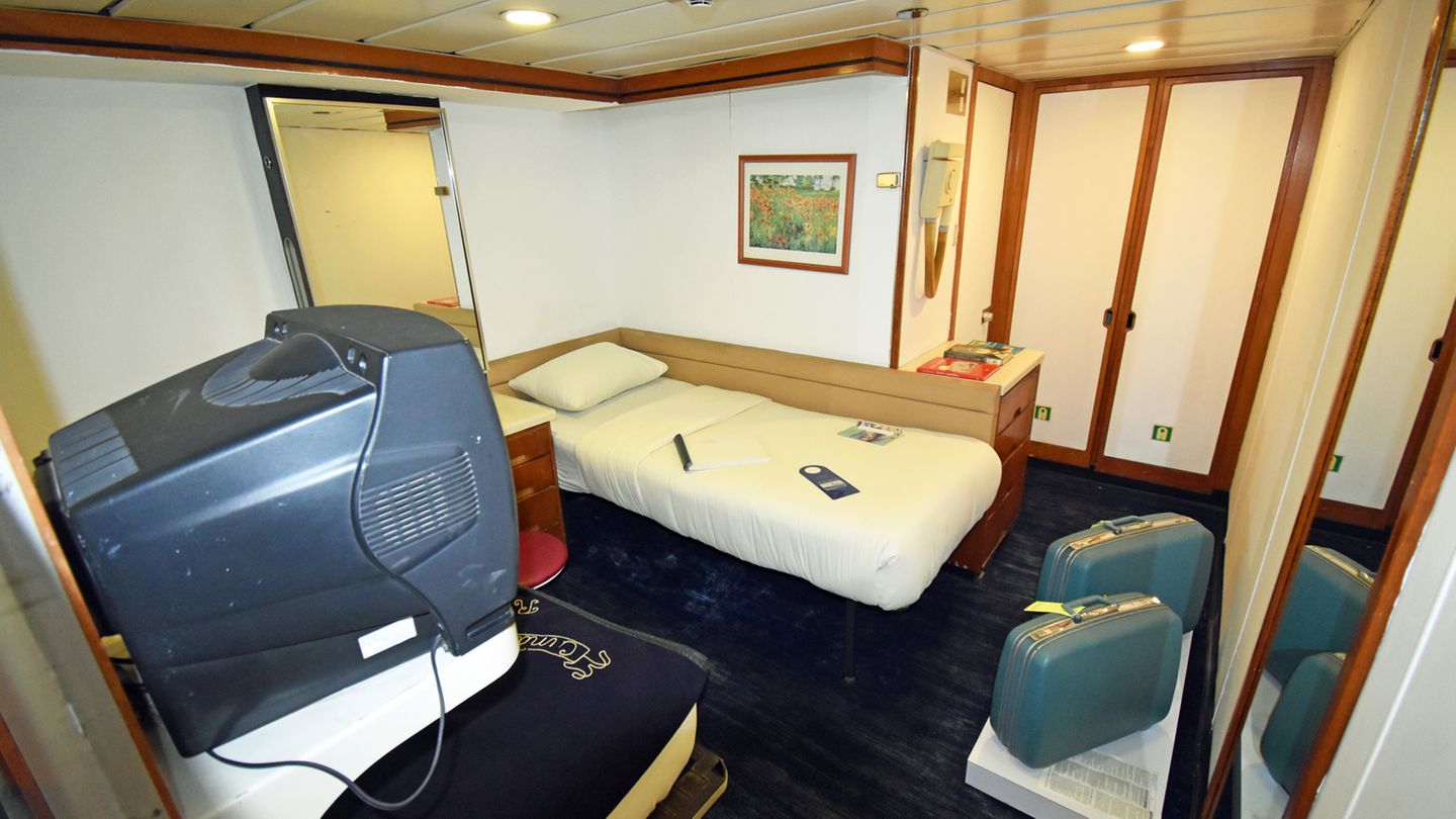 Einzelkabine auf dem Schiff QUE1, dekoriert von alten Koffern und einem Röhrenfernseher