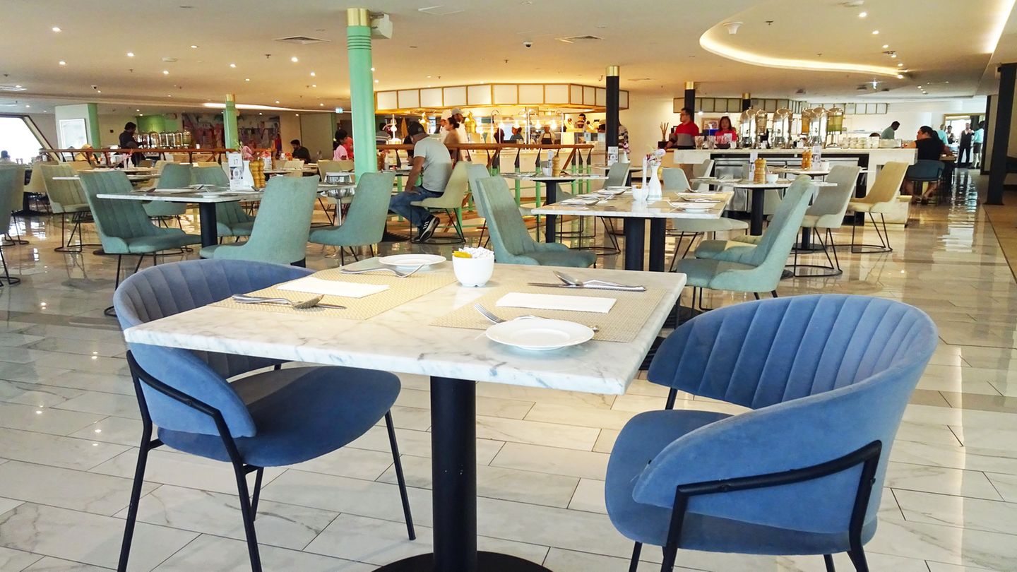 Modernes Restaurant "Lido" mit blauen Samtstühlen und marmorierten Bistrotischen