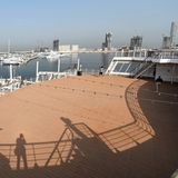 Große Holzterrasse auf dem Außendeck mit Lichterketten und Blick auf den Dubaier Hafen