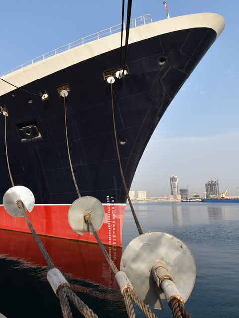 Die Qeen Elizabeth 2, ein schwarzes Schiff mit rotem Unterteil, im Hafen von Dubai